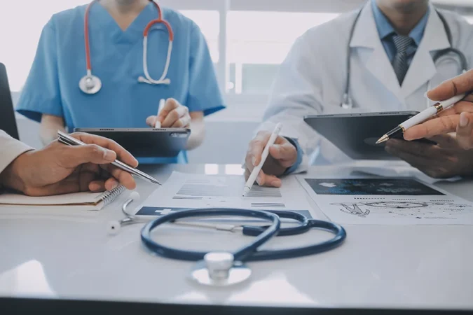 Doctors Meeting with Tablet Patient Data Analysis