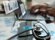 Healthcare professional analyzing billing metrics and charts on a laptop with digital overlays, symbolizing KPI tracking in emergency and urgent care billing.